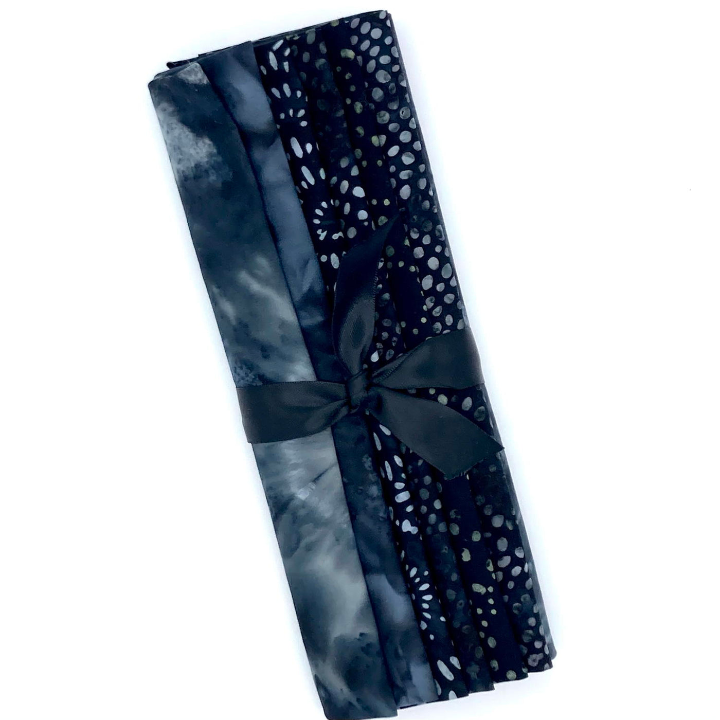 Six different grey and dark grey toned batik fabric fat quarters in a bundle tied with a black ribbon.