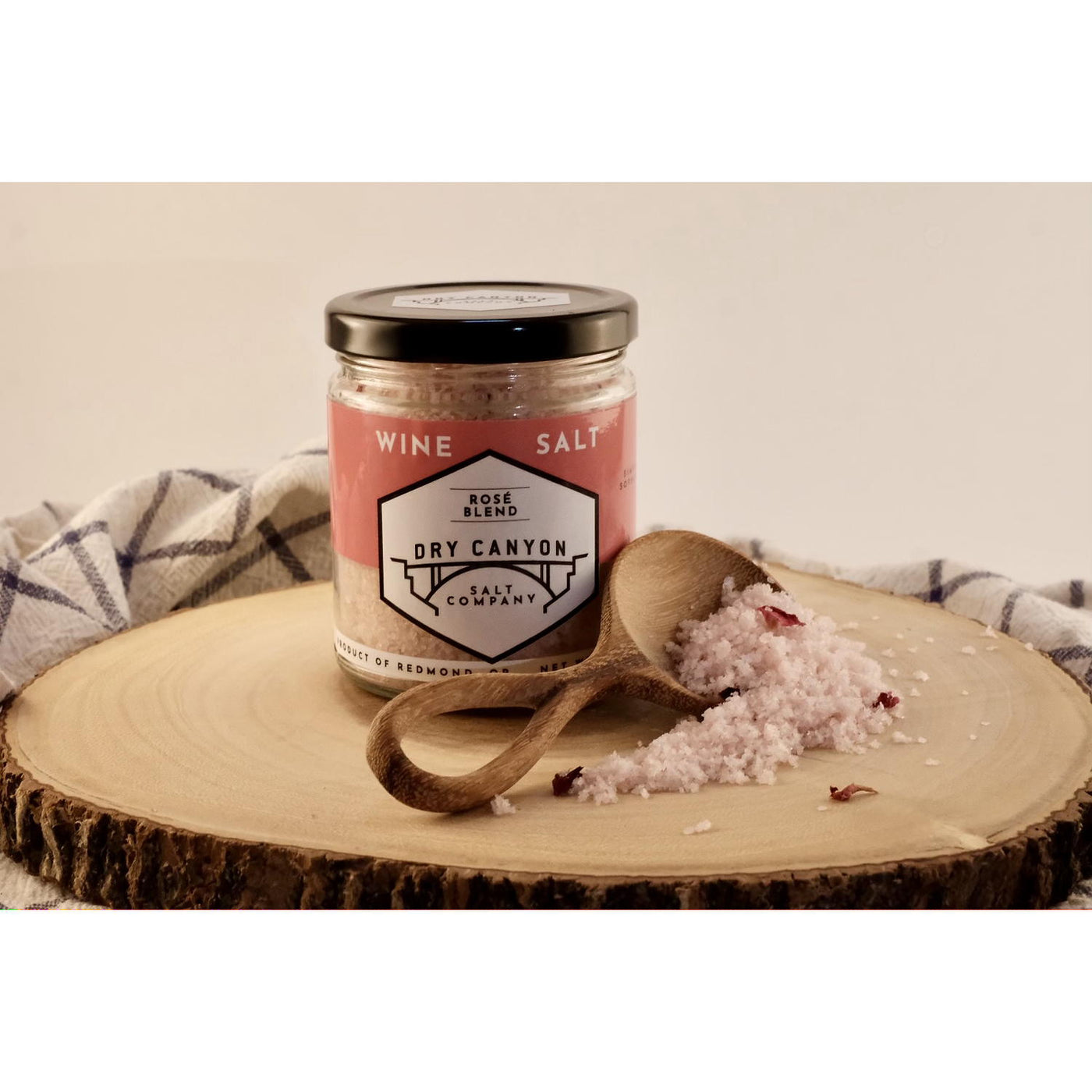 Jar of Dry Canyon wine salt on a wooden board with a wooden spoon