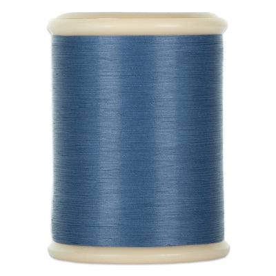 Spool of blue thread on a white background